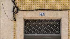 A gray door with a number plate, a keypad, and a window with a grid pattern. - Urbsc3 · Santa Catarina Studios · Apt 3 (Porto)
