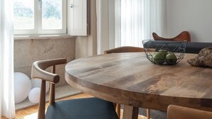 En matplats med ett träbord, svarta stolar och en svart hänglampa.