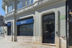 A building with a sign reading "BBVA" and an ATM sign. - Prt003 · Charming Apartment Porto (Porto)