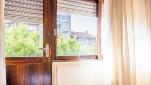 A wooden door with a window, a view of greenery and buildings outside. - Marino · 3bed apt Close to Casa da Musica (Porto)