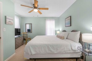 Cozy retreat with a large bed, bedside tables, and a ceiling fan for a comfortable stay.