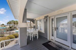 Enjoy dining or socializing in this outdoor space with a table and chairs, adjacent to a pool.