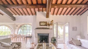 A spacious living room with a fireplace, large windows, and a cozy seating area. - Villa surrounded by vineyards with private pool near Orvieto (Terni)