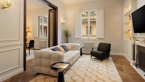Un salon avec un canapé, un fauteuil, une petite table et une cheminée.