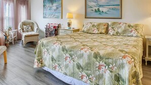 A spacious bedroom with a large bed, a ceiling fan, and two paintings on the walls. - Ocean Bliss 2BD Villa on St Augustine Beach (St. Augustine)