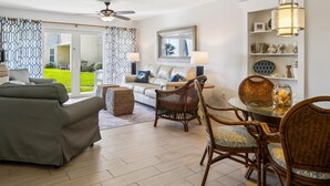 A spacious living room with a sofa, chairs, a dining table, and a ceiling fan. - Ocean Oasis Relax Near Historic St Augustine (St. Augustine)