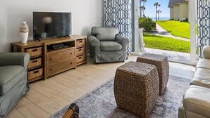 A living room with a TV, sofa, and a ceiling fan. - Ocean Oasis Relax Near Historic St Augustine (St. Augustine)