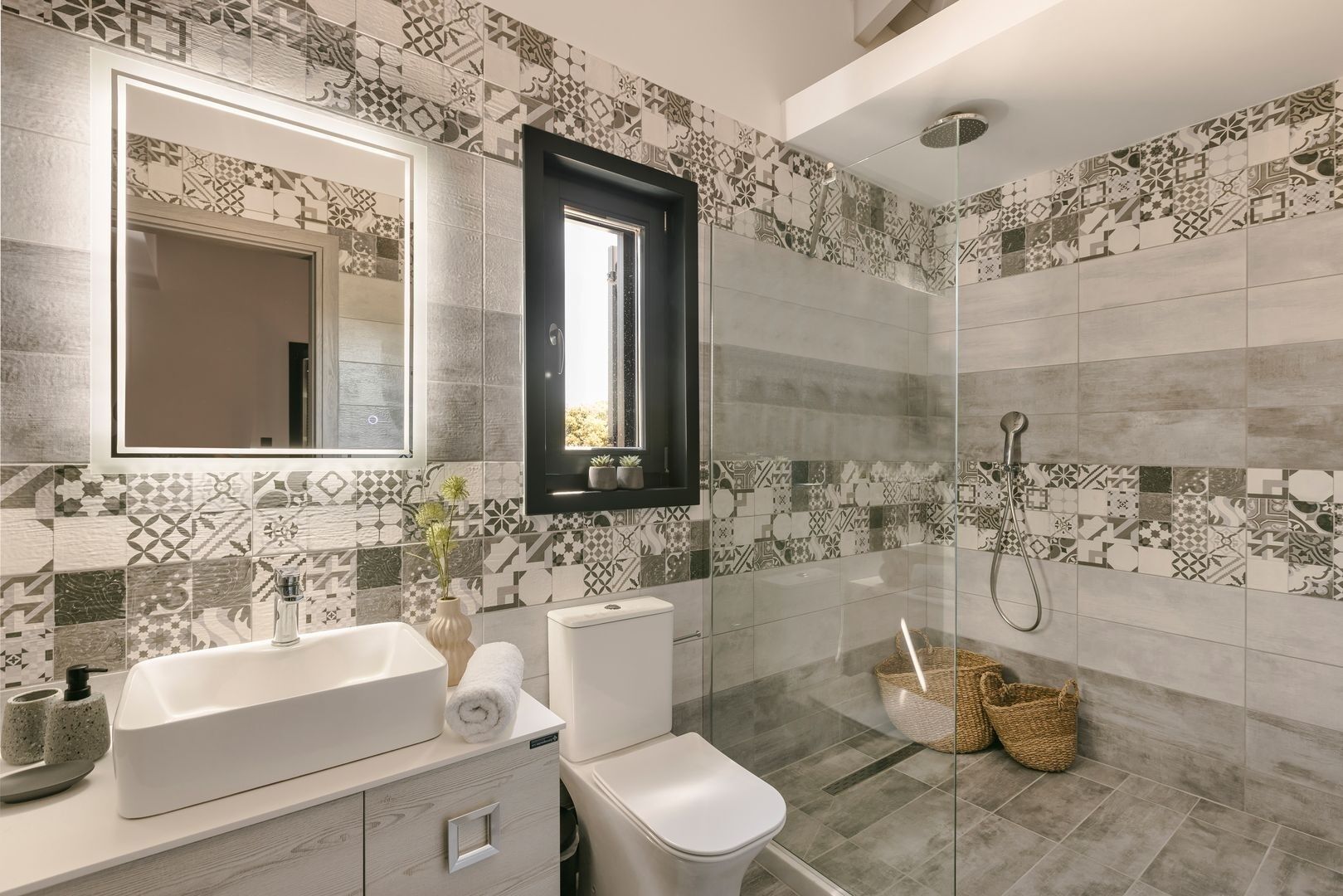 A modern bathroom with a large mirror, a built-in sink, a toilet, and a shower area.