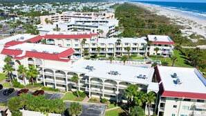Un complexe hôtelier comprenant plusieurs bâtiments, une piscine et offrant une vue sur la plage.