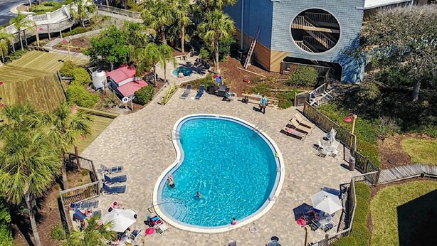Ett semesterparadis med en stor pool, palmer och utsikt över havet.