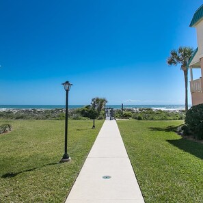 A pathway leading to a beach with a clear view of the ocean.
