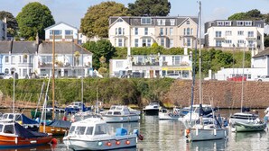 A marina with various boats docked, surrounded by residential buildings with multiple stories and balconies. - Quayside View in Paignton (Paignton)