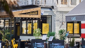 Straatbeeld met verschillende gelegenheden, waaronder een visrestaurant, een café en een bar.