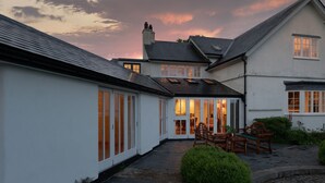 A residential building with a covered patio area, stone paving, and a well-maintained garden. - Higher Mapstone in Lustleigh (Newton Abbot)