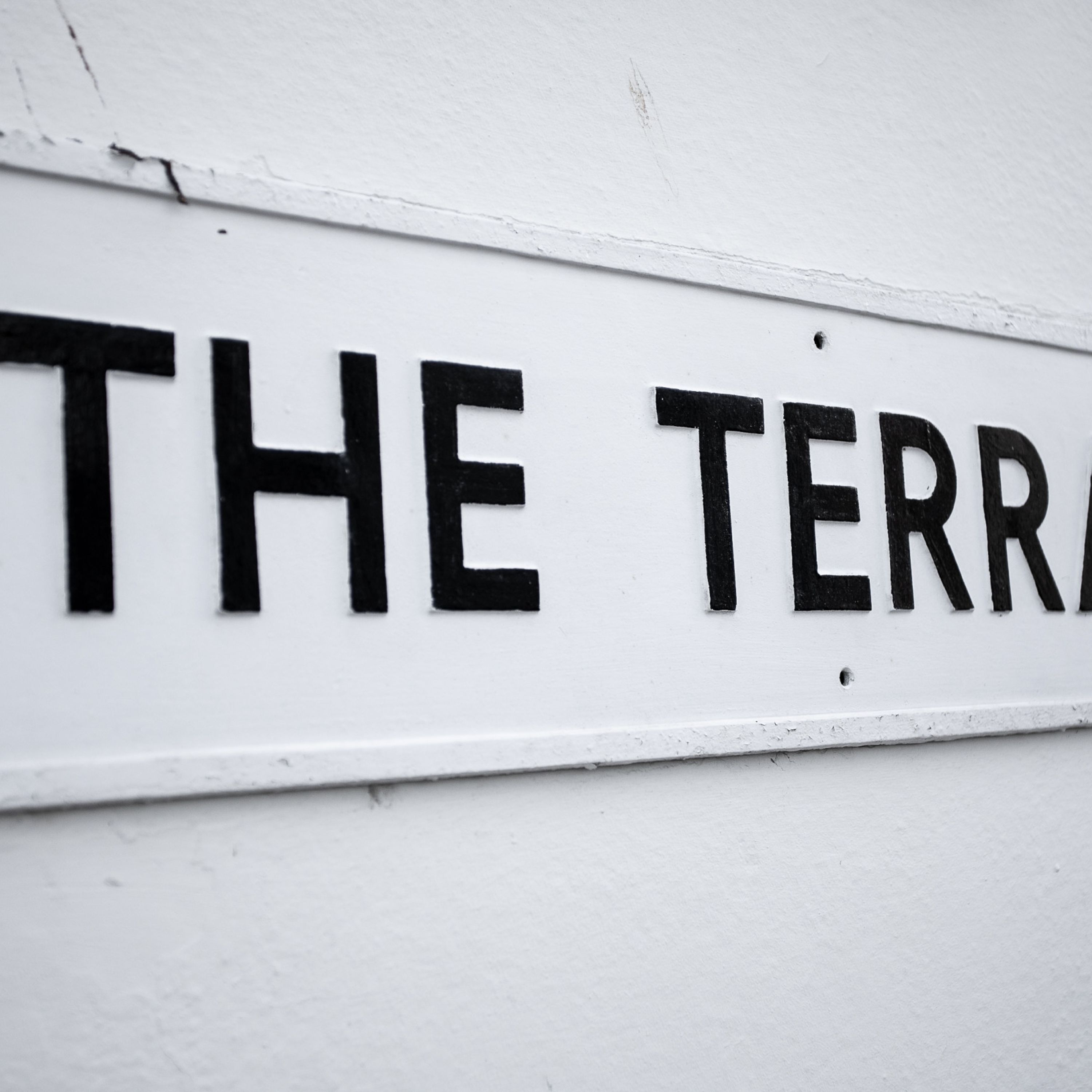 A white wall with black text that reads "THE TERR".