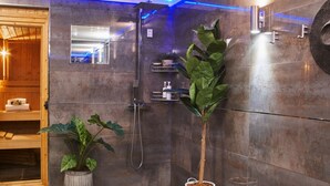 A modern bathroom with a shower, a potted plant, and a wooden bench. - Swifts Return in Lower Ashton (Newton Abbot)