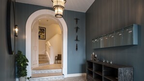 A hallway with a patterned floor, a wooden bench, a wall-mounted cabinet, and a staircase leading to another room. - Cathedral Yard in Exeter (Exeter)
