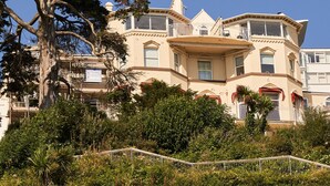 A large, historic mansion with multiple stories, a prominent bay window, and a balcony. - Bayfort Sea Studio in Torquay (Torquay)