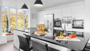 A modern kitchen with a central island, stainless steel appliances, and large windows. - Homefield in Dartmouth (Dartmouth)