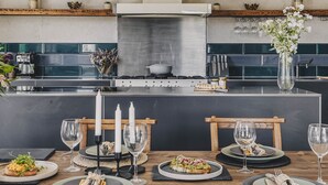 A modern kitchen with a central island, built-in appliances, and a dining area set for six.