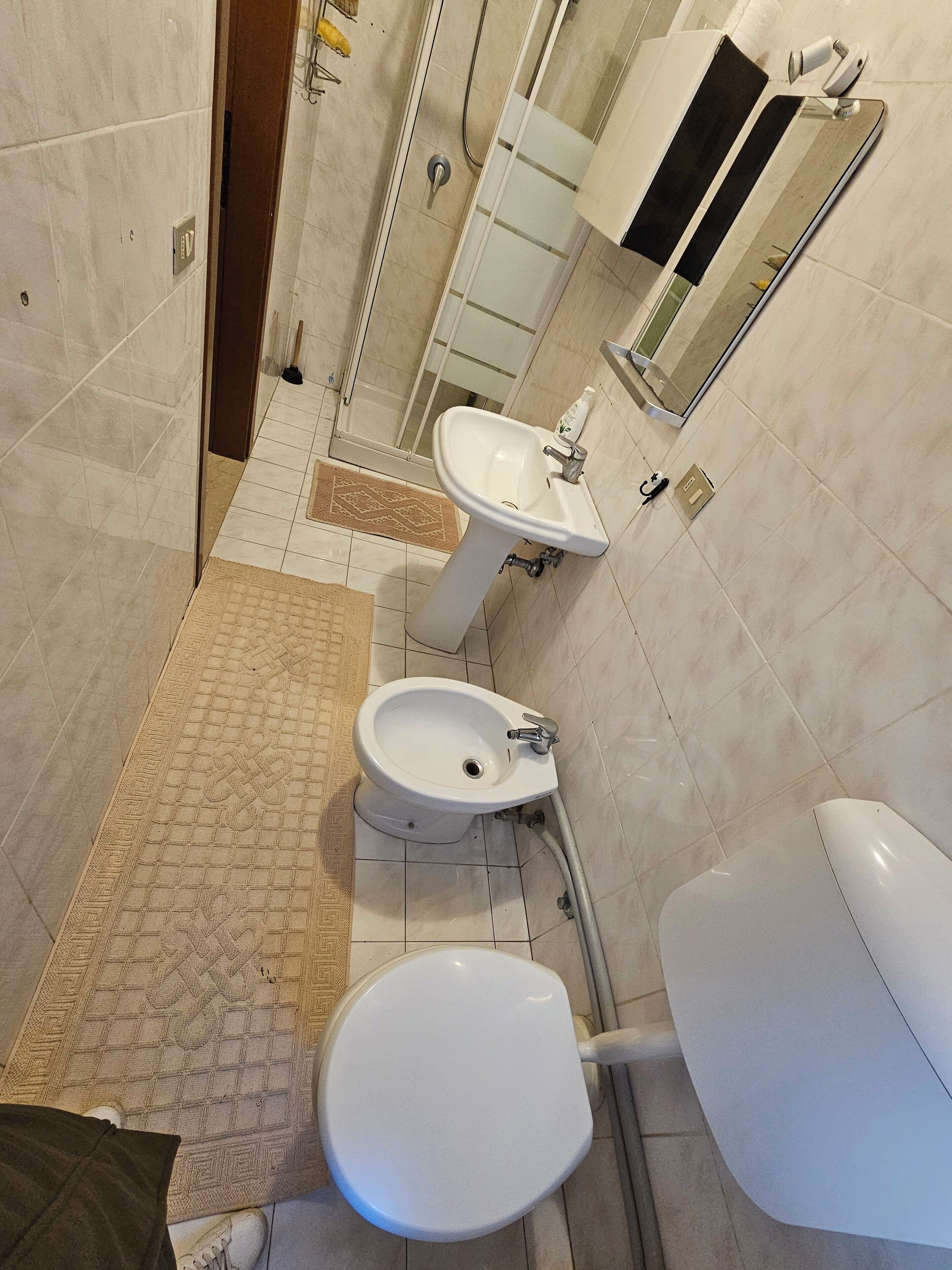 Un baño con inodoro, lavamanos y bidé.