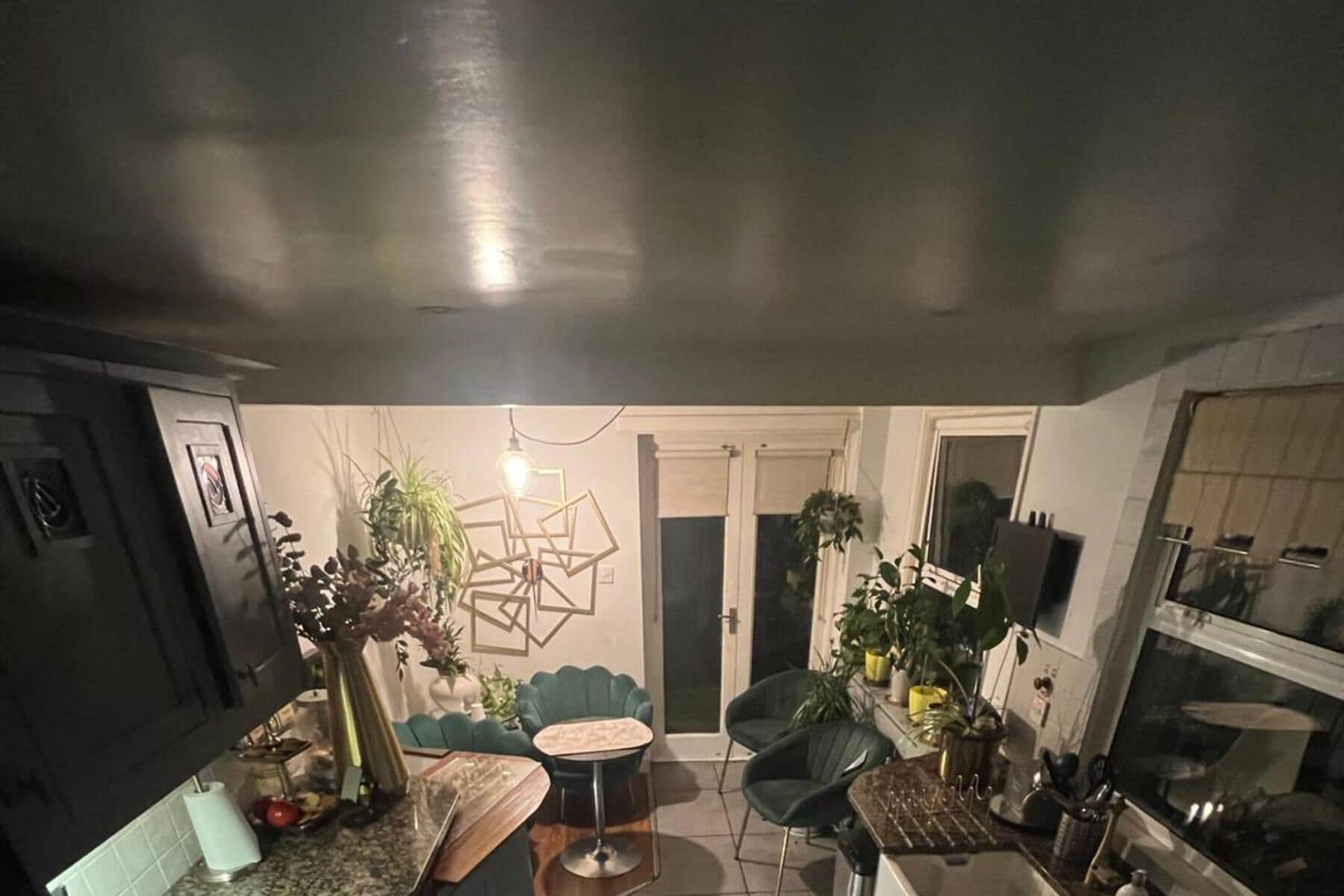 A compact living space with a dining area, a sofa, a coffee table, and a kitchen area with a stove and sink.