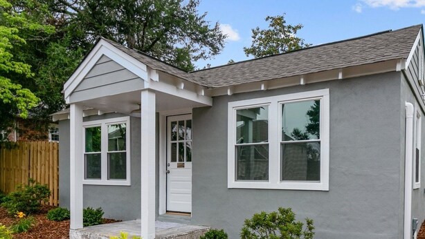 A single-story house with a gray exterior, white trim, and a front porch. - Walkable Cottage, Pet Friendly with Fenced Patio (Southern Pines)