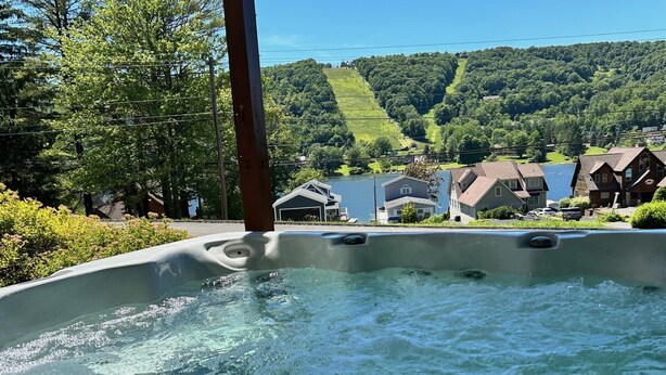 Un jacuzzi con vista a una zona residencial y colinas al fondo.