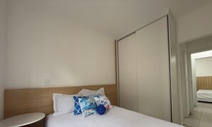 Une chambre d’hôtel avec un lit, une table de chevet et une armoire.