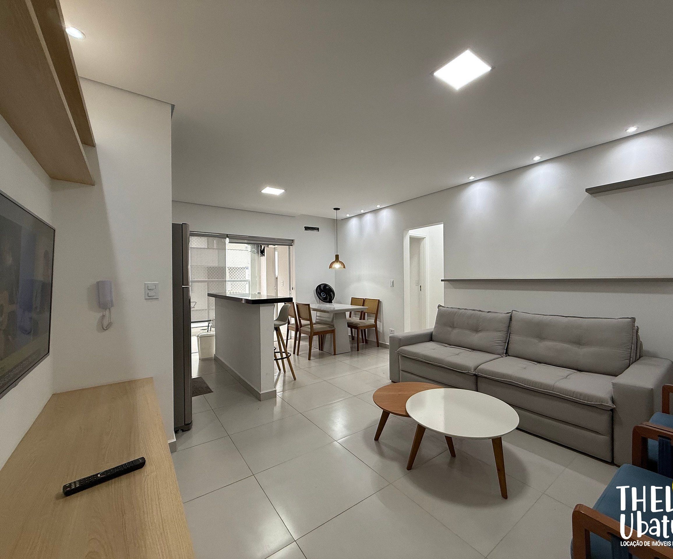 Uma sala de estar moderna com um sofá, uma mesa de centro e uma área de jantar com cadeiras e uma mesa.
