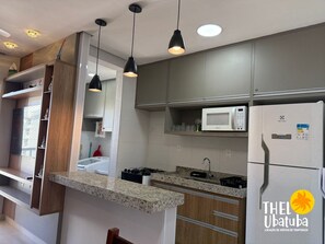 Fridge, microwave, oven, cookware/dishes/utensils - Thel Ubatuba - Praia Grande - Cond Saint Barth 36/C (Ubatuba)