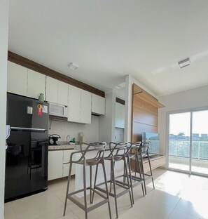 Een koelkast, een magnetron, een oven, kookgerei, borden en bestek