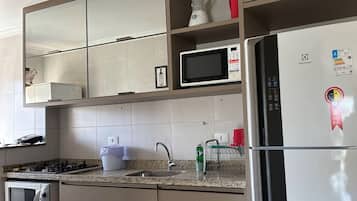 Una cocina moderna con microondas integrado, refrigerador, estufa y lavaplatos.