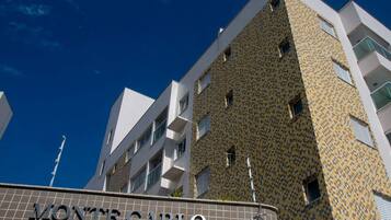 A building with a patterned facade and the name "MONTECARLO" on the ground floor.