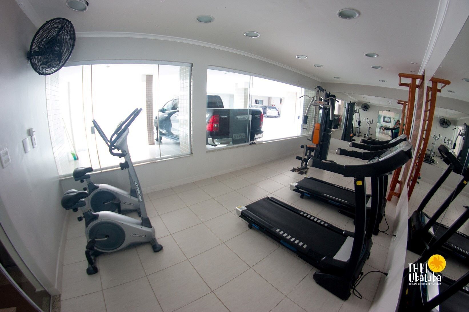 Un gimnasio con cintas de correr, elípticas y bicicletas estáticas.