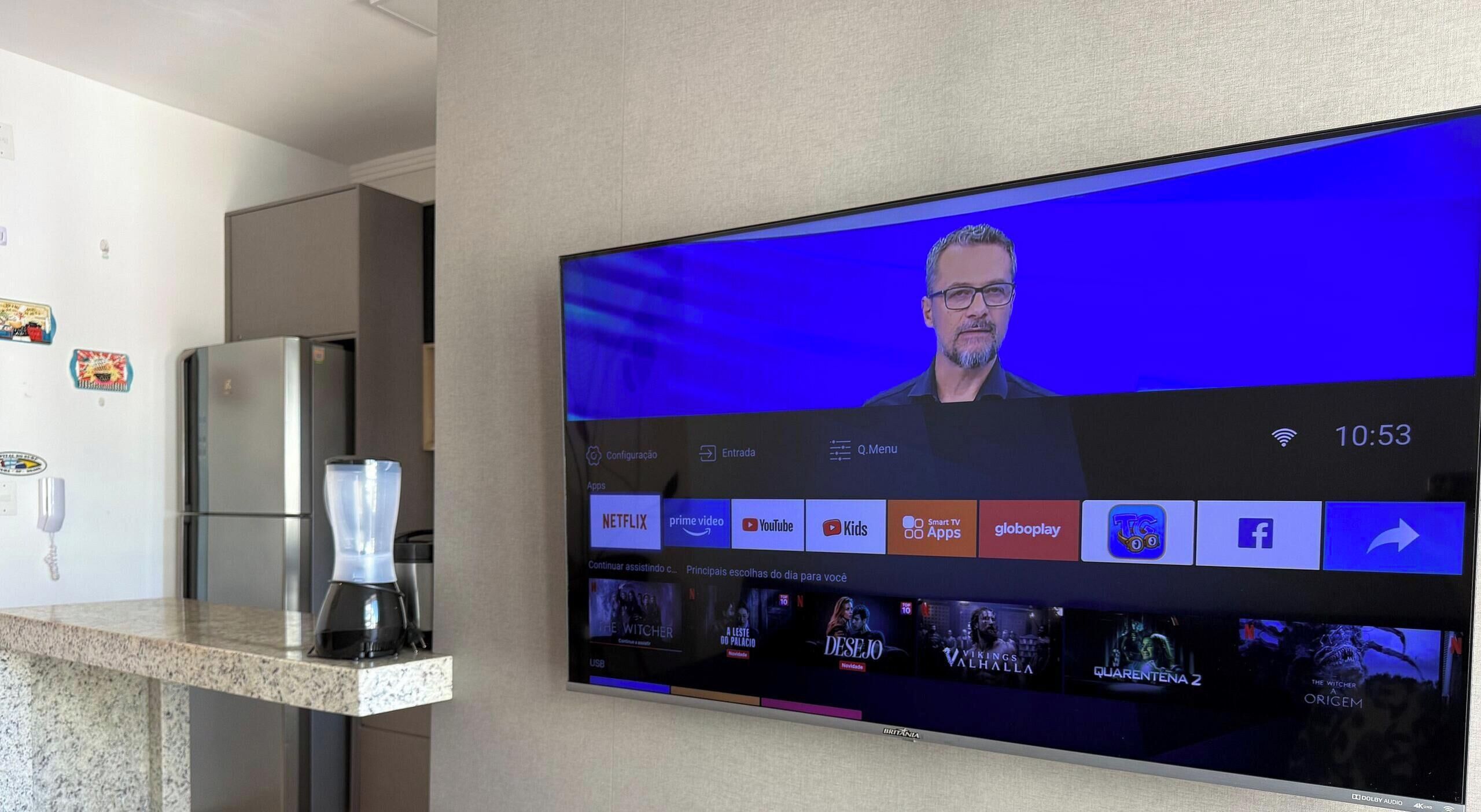 Een flatscreen-tv aan een muur, met een streaming interface, diverse apps en een timer ingesteld op 10:53.