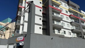 Ein mehrstöckiges Gebäude mit Balkonen, einem sichtbaren 'ibiza' Schild und blauem Himmel.