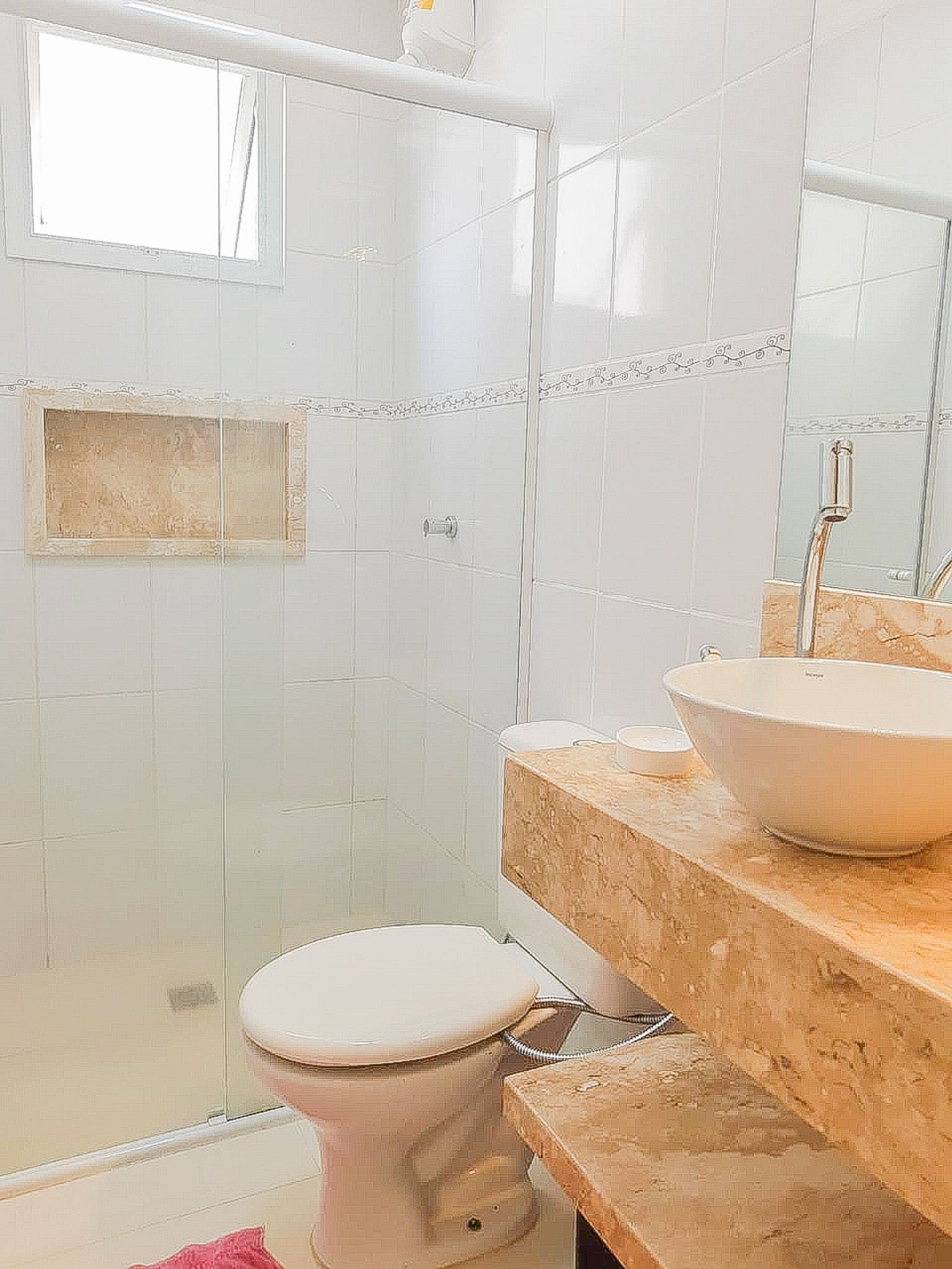 A bathroom with a toilet, a sink with a vessel basin, and a shower area.
