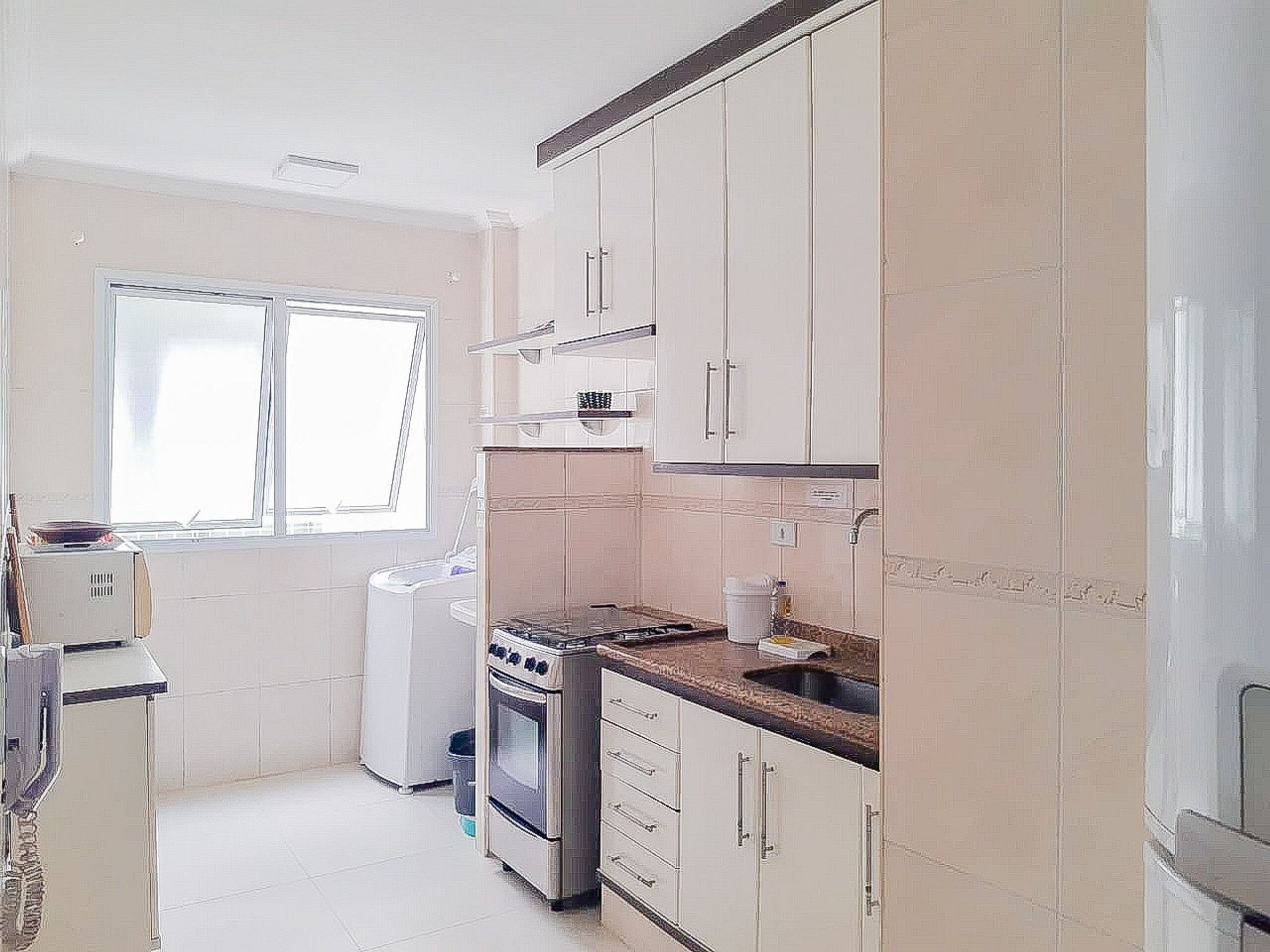 A kitchen with white cabinets, a stove, and a window.