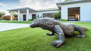 A modern house with a large garage door and a well-maintained lawn. - Superbe Villa vue mer sur st Tropez (Sainte-Maxime)