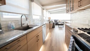A modern kitchen with a sink, countertop, and cabinets. - La Jolla Windansea Luxury Cottage (San Diego)