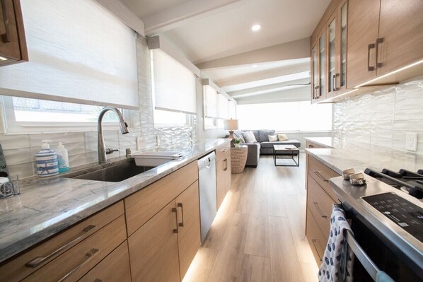 A modern kitchen with a sink, countertop, and cabinets.
