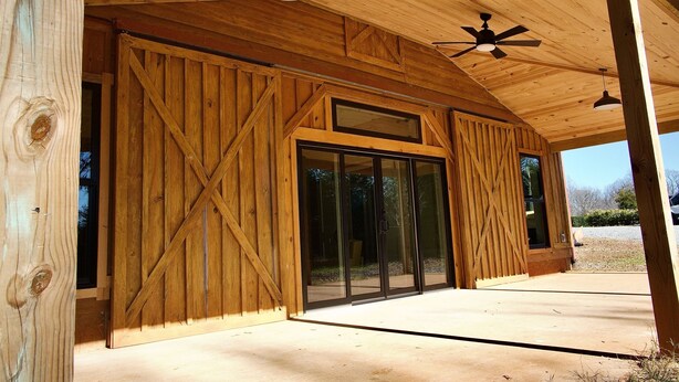 A wooden building with large sliding glass doors, a ceiling fan, and a light fixture. - Serenity Barn, cozy barn-dominium with a great locatoin (Mooresville)