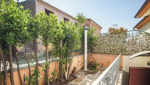 A residential area with a staircase leading to a house, surrounded by greenery and a fence. - Petali di Rosa – A Due Passi dalla Spiaggia (Loiri)