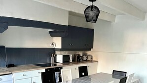 Una cocina compacta con comedor, lavadora y lámpara en el techo.