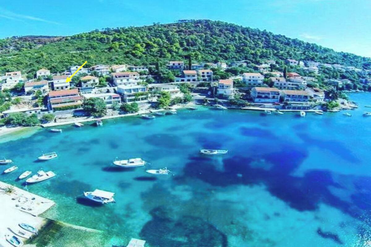 A coastal town with buildings along the shore and boats in the water.