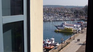 A marina with boats docked, a lifeboat, and a clear view of the water. - Sardinia RE - Alma Boh Mien Stunning View (Alghero)