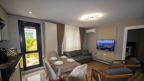 A modern living room with a dining area, a sofa, and a TV. - Luxury Life Suites (Istanbul)