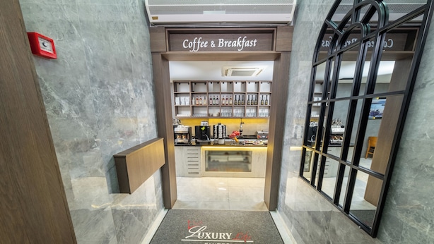 A hotel entrance with a coffee and breakfast area, a reception desk, and a sign for luxury suites. - Luxury Life Suites (Istanbul)