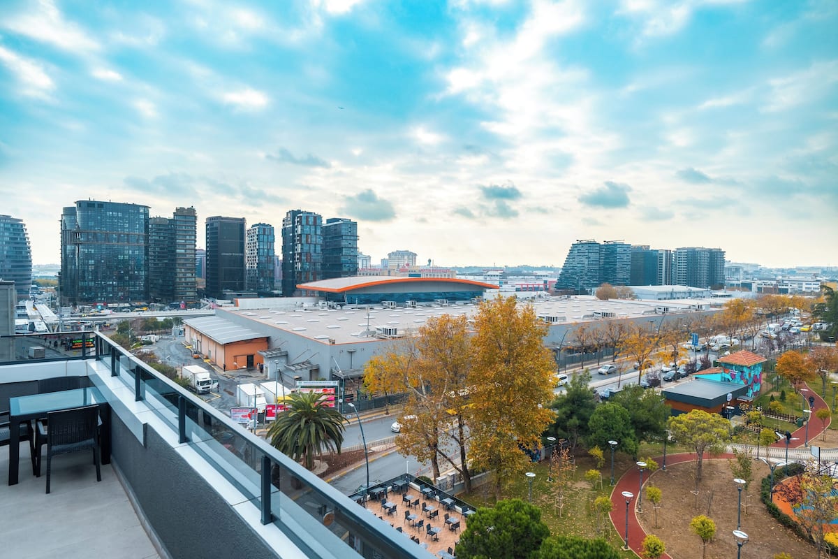 A high-rise building with a modern architectural design, featuring a curved roof and multiple floors.